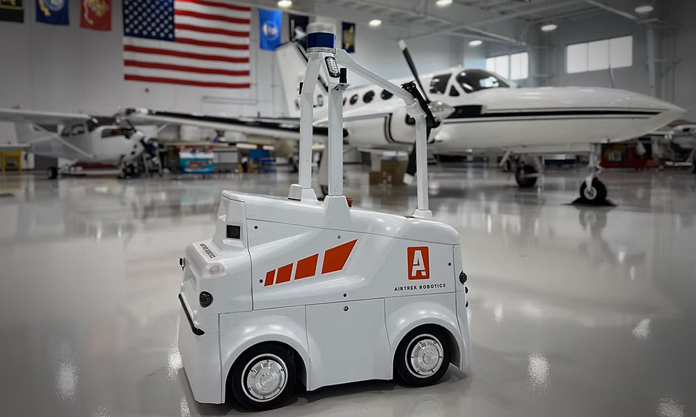 An Airtrek robot drives through a plane hangar